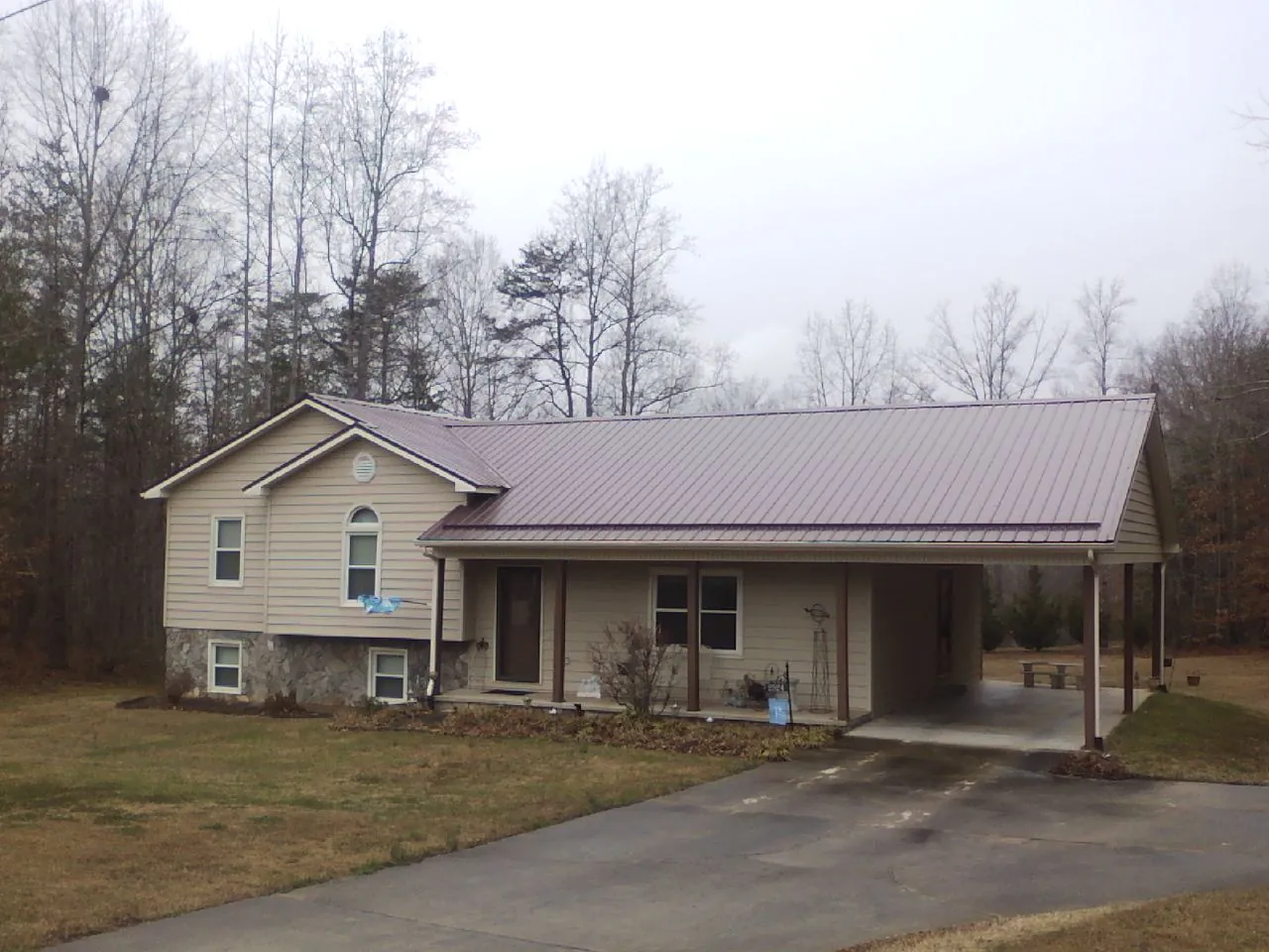 Burgundy metal roof on a tan split level home with an attached carport in Dundalk