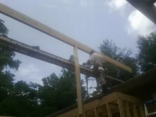Carpenter setting a ridge beam over a new addition frame — Ice Dam Removal by Roofing Brothers in Dundalk