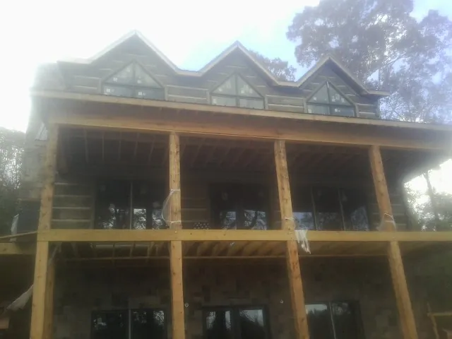 Dormers and porch framing on a large log home under construction — Roof Coating work by our crew in Dundalk