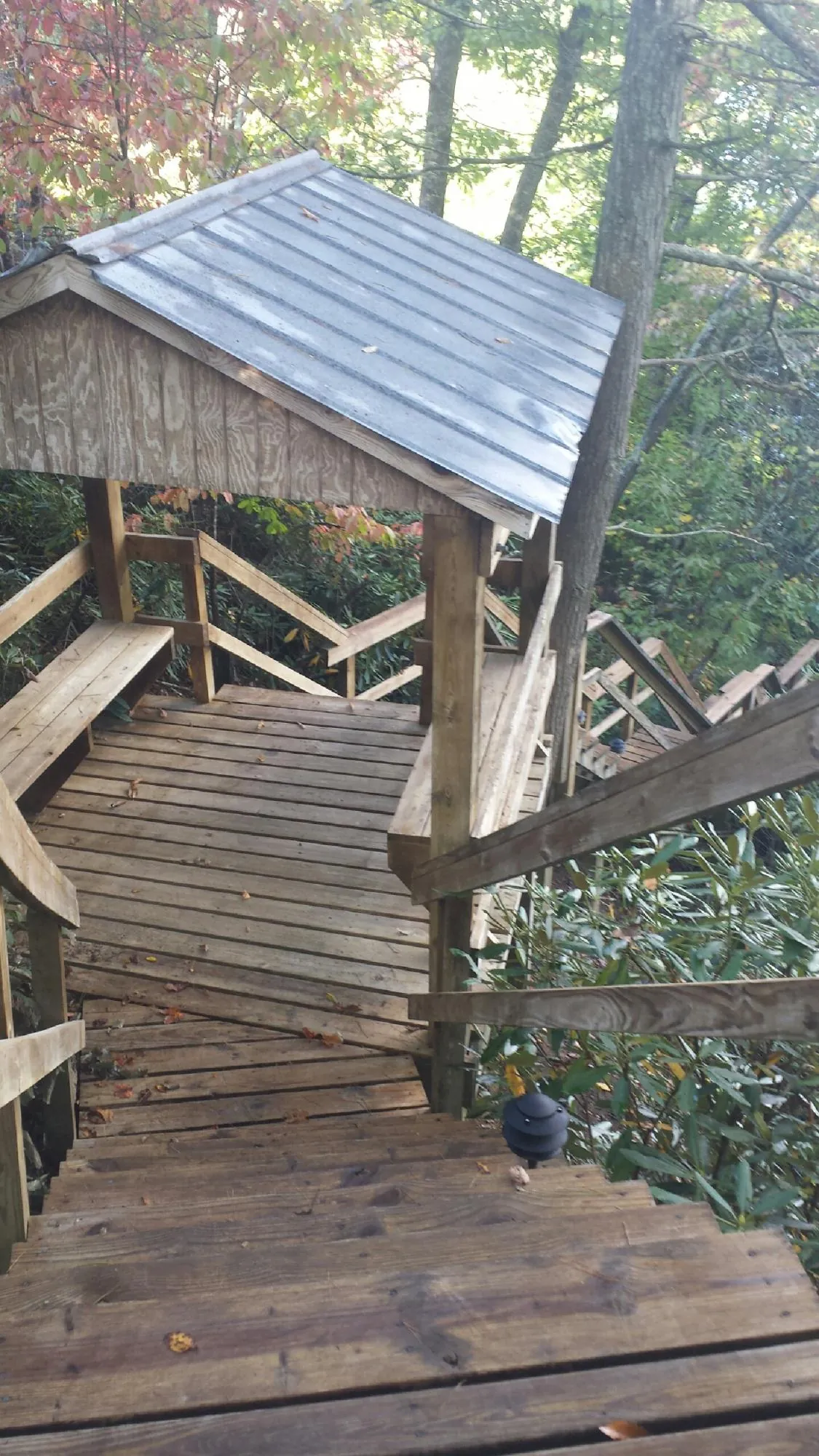 Metal roofed shelter over wooden steps on a wooded walkway — Skylight Repair & Installation work by our crew in Dundalk
