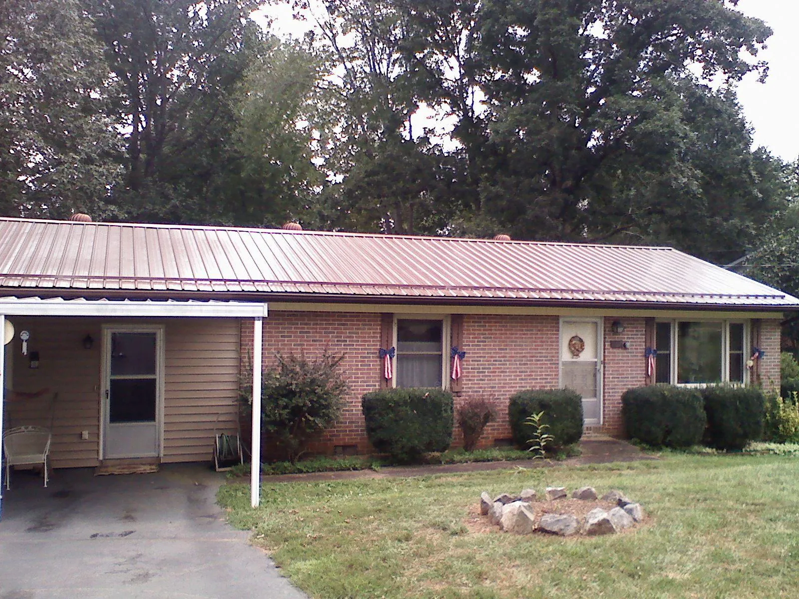 Bronze metal roof and carport on a brick ranch home — Roof Repair work by our crew in Dundalk